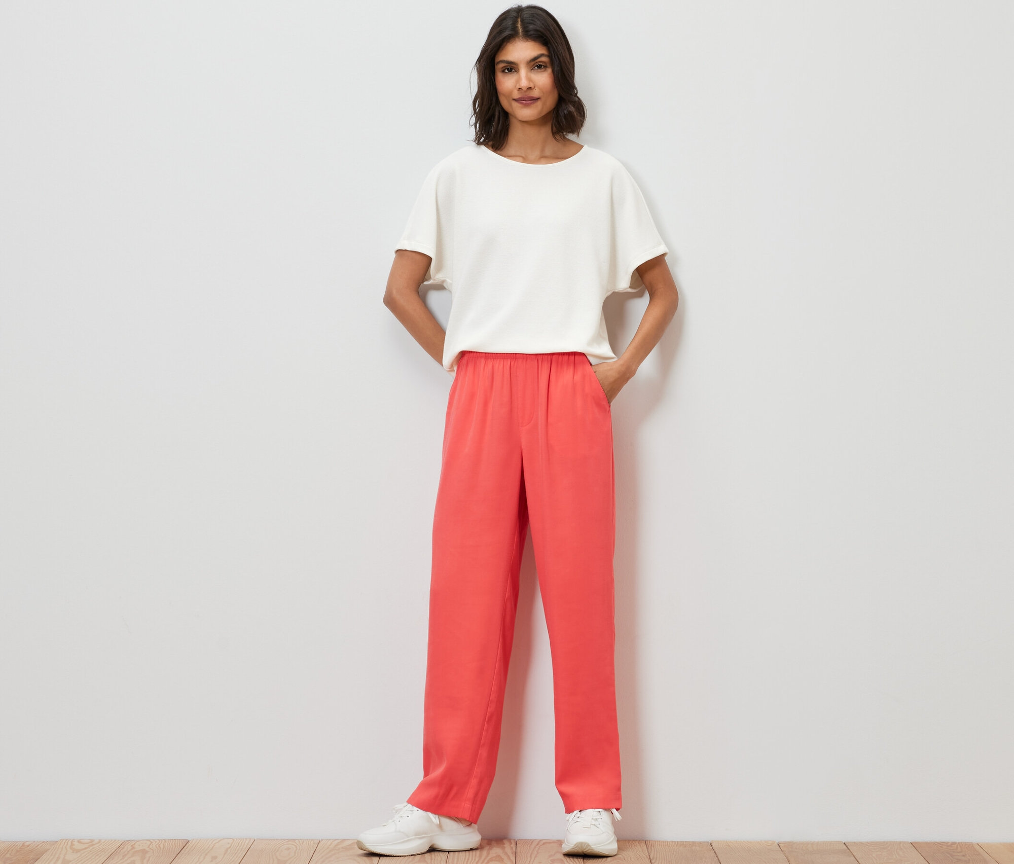 Frau steht mit Händen in den Taschen der Webhose.