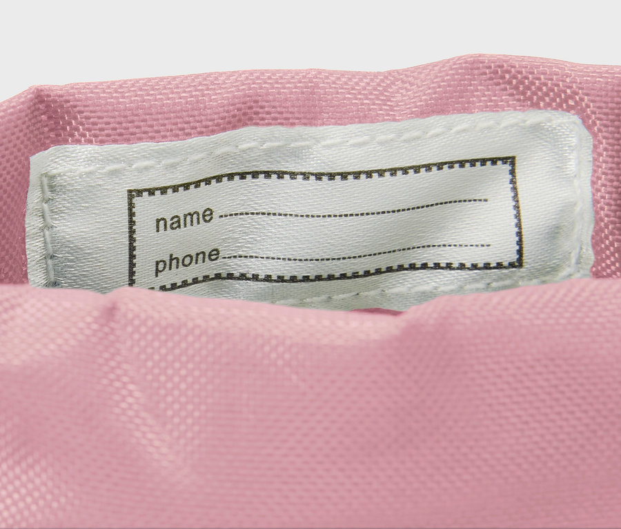 Detail eines Kinder-Gummistiefels mit Blumen-Alloverprint, der ein Namensschild zeigt.