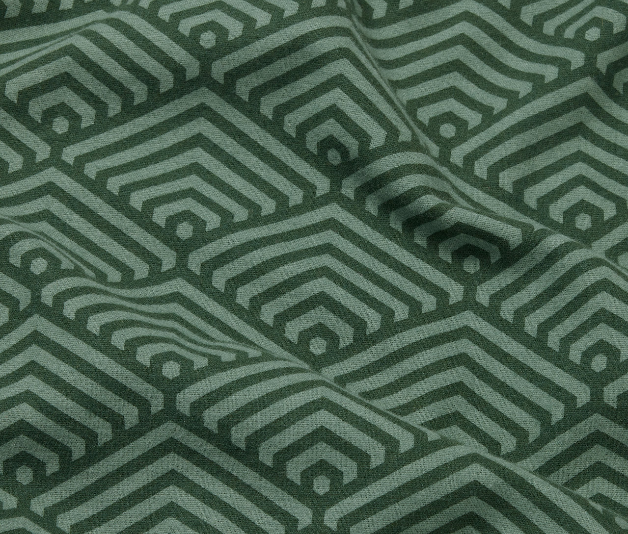 Nahaufnahme von zwei grünen Biber-Kopfkissenbezügen mit geometrischem Muster.