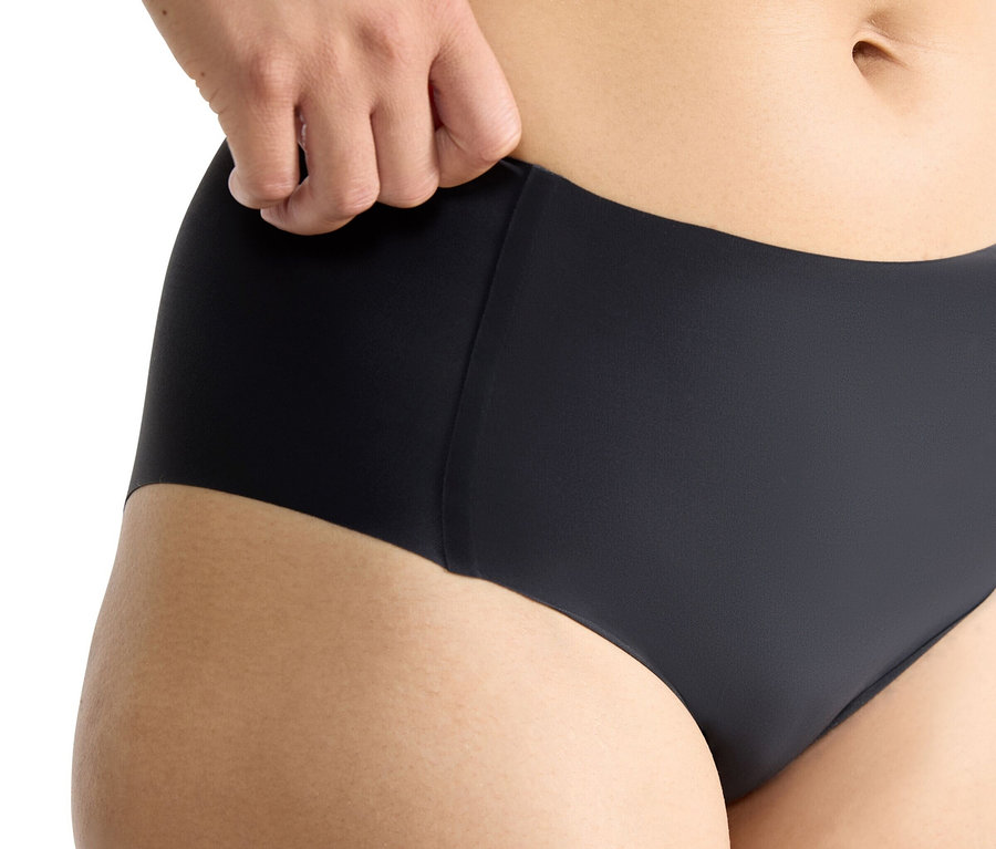 Nahaufnahme einer Person, die eine schwarze Unterhose hält.