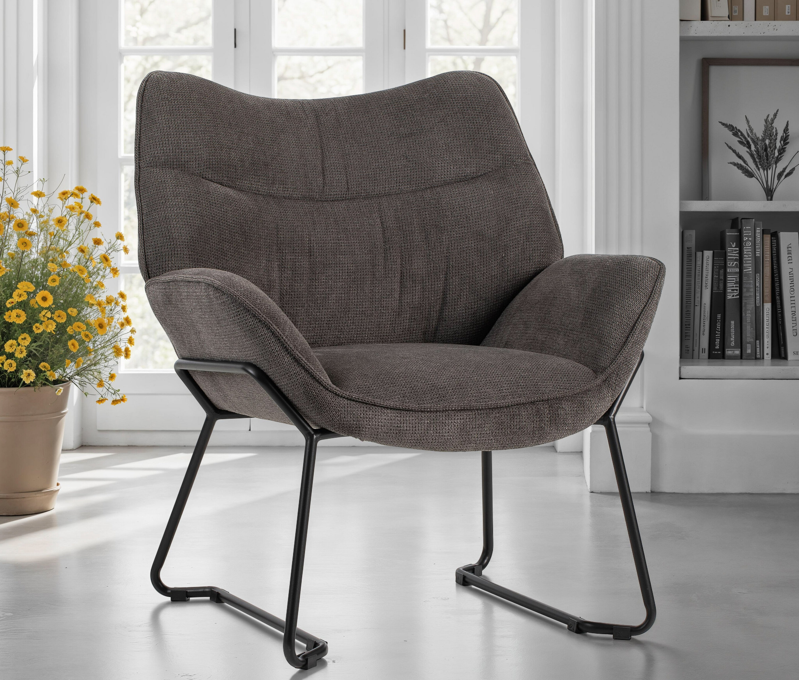 Ein grauer DeVries Sessel »Aliano« steht vor einem Fenster.