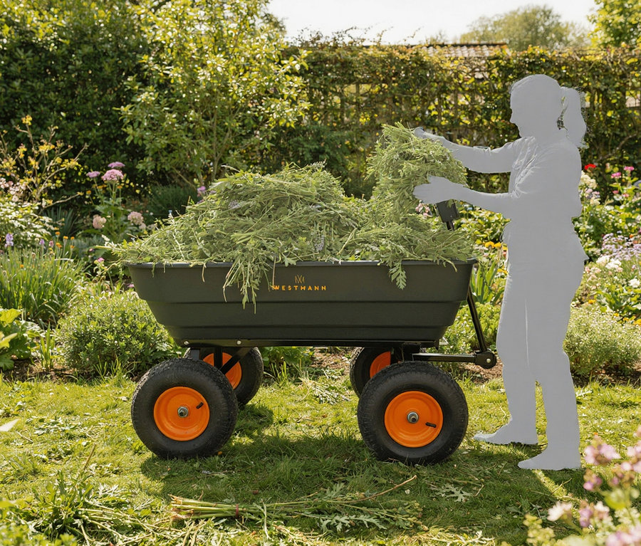 Eine Person befüllt einen Westmann »Prakta L«, großen Gartenwagen mit Kippfunktion mit Grünabfällen in einem Garten.