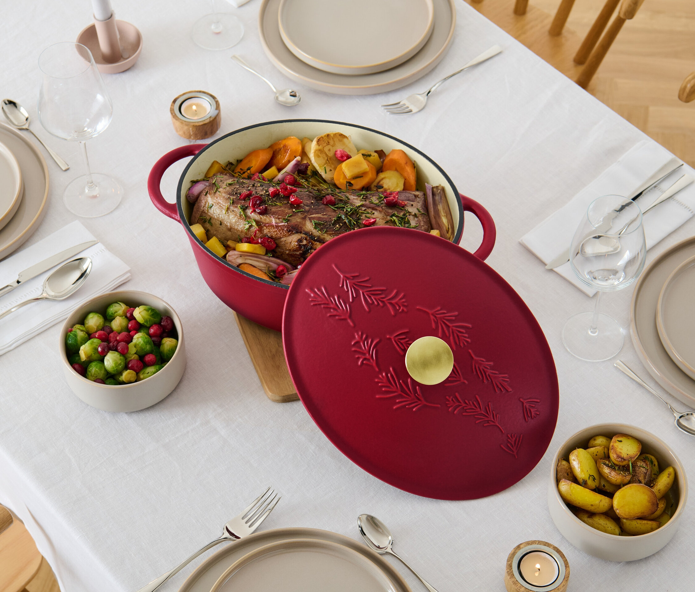 Speise im ovalen Gusseisen-Bräter auf gedecktem Tisch.