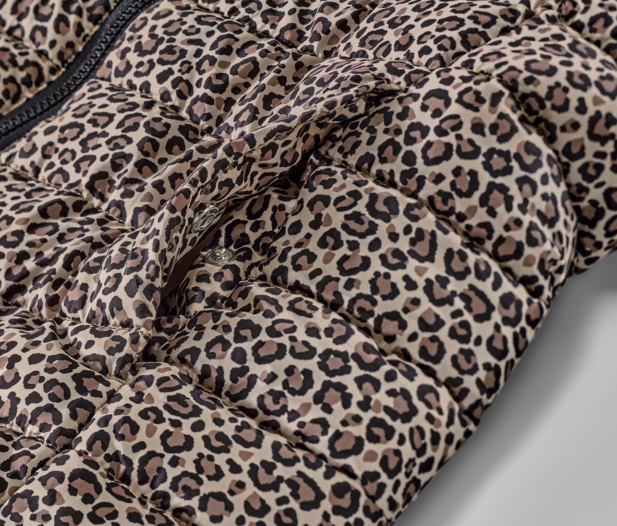 Detailansicht einer bedruckten Steppweste mit Kapuze und Druckknöpfen.