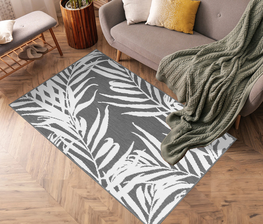 Grauer Outdoor-Wende-Teppich »Palm Tree« liegt im Wohnzimmer.