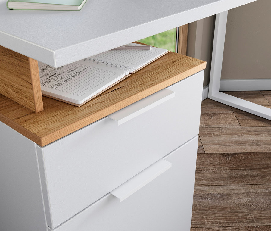 Detailansicht eines weißen Schreibtischs mit dem Container »Hasselt«, auf dem ein offenes Notizbuch liegt.