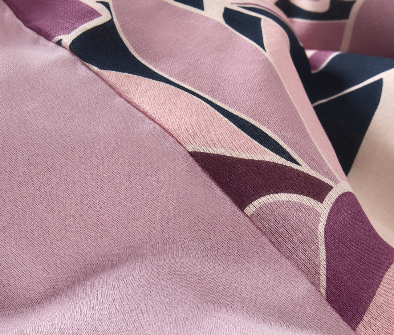 Detail einer Renforcé-Bettwäsche in Normalgröße mit lila Blumenmuster.