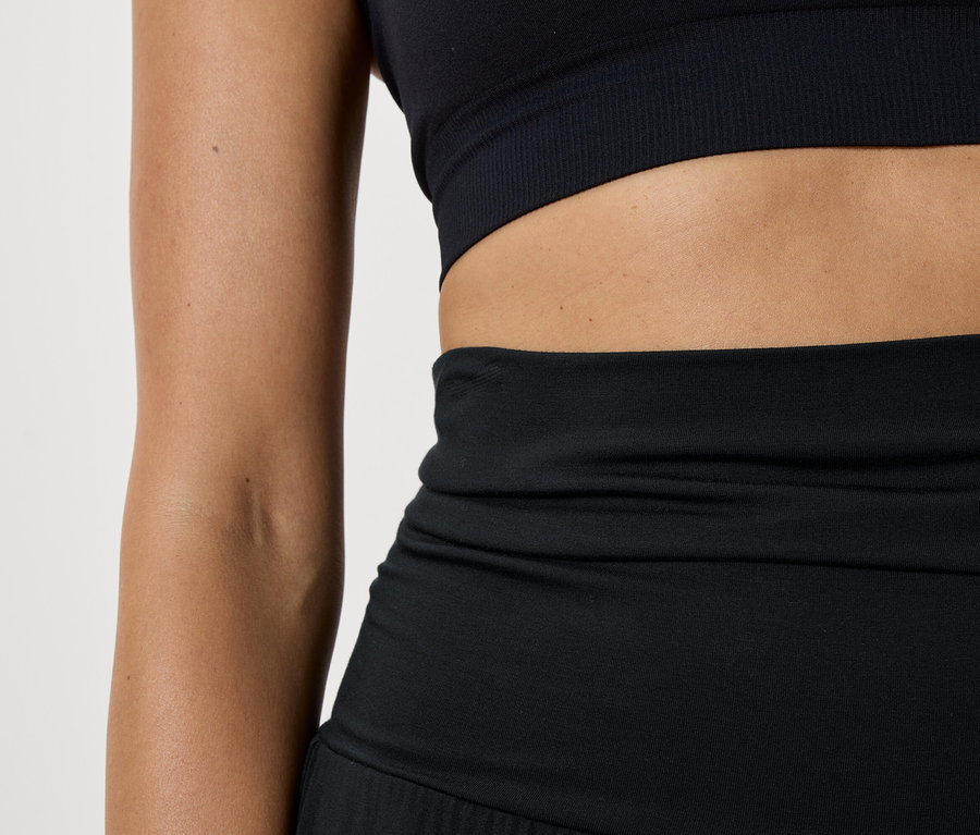 Detailaufnahme von Damen Sportbekleidung, bestehend aus einem schwarzen Sport-BH und Leggings.