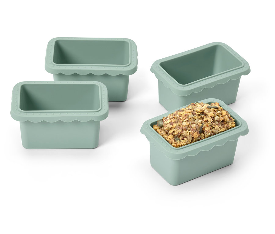 Vier grüne Silikon-Eiswürfelformen, eine mit Eiswürfeln gefüllt.