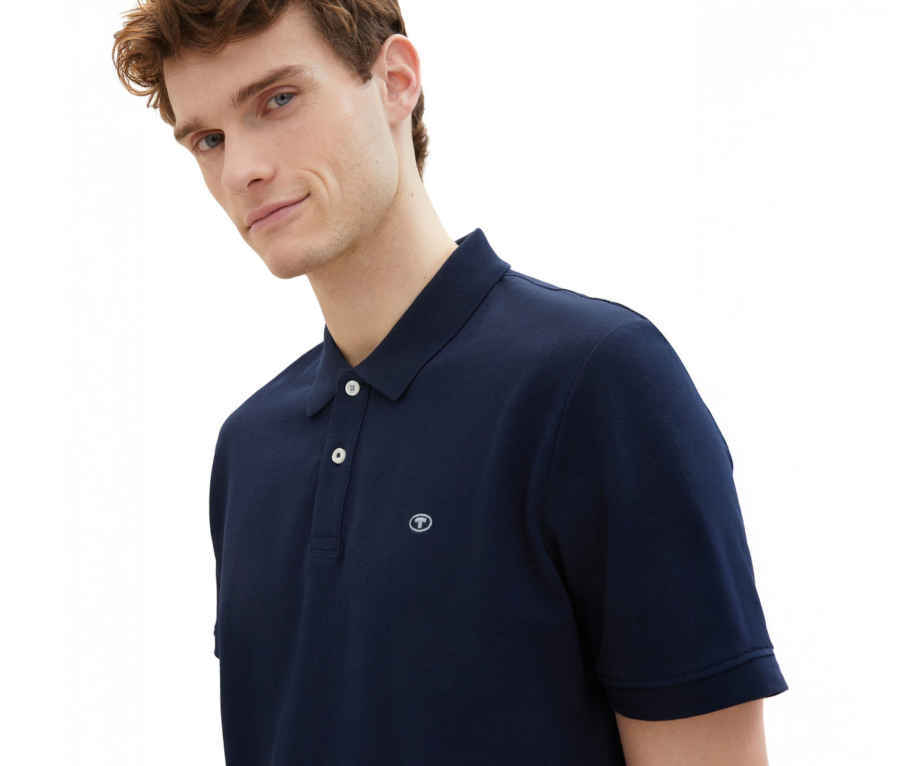 Mann trägt ein Tom Tailor Piqué Poloshirt in Sky Captain Blue.