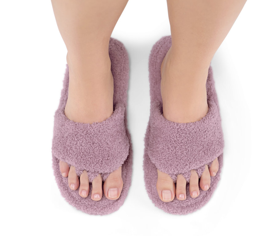 Draufsicht auf Füße in Lackier-und-Entspannungspantoletten.