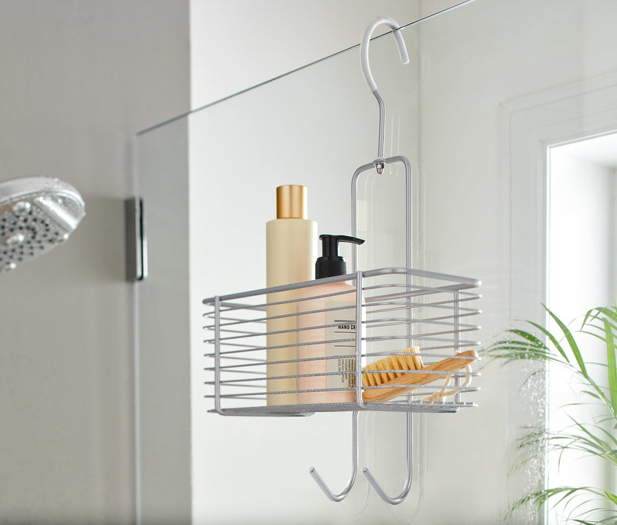 Ein Duschregal zum Aufhängen mit Kosmetika und einer Bürste in einer Duschkabine.