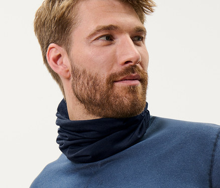 Mann mit braunen Haaren trägt ein blaues Multifunktionstuch mit RWS-zertifizierter Wolle und ein blaues Oberteil.