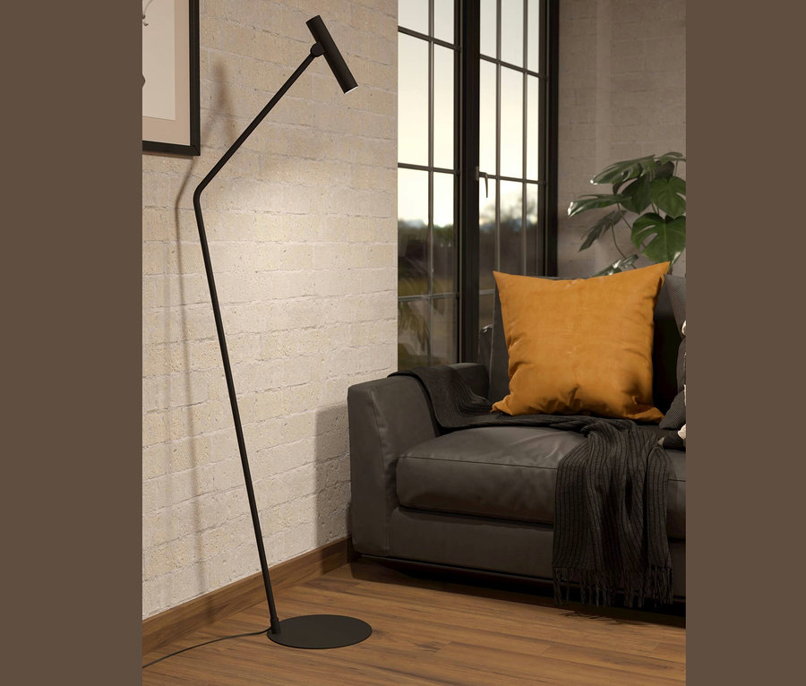 Eine schwarze Eglo Stehlampe »Almudaina« steht neben einem grauen Sofa mit senfgelbem Kissen.
