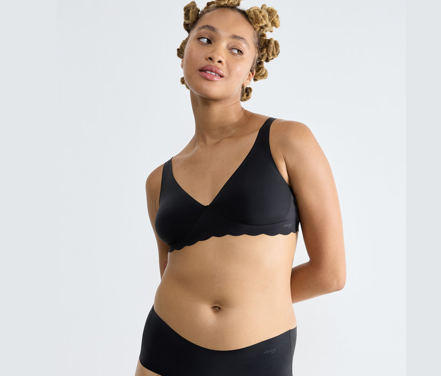 Frau trägt einen schwarzen Sloggi ZERO Microfibre 2.0 Soft BH und schwarze Slips.