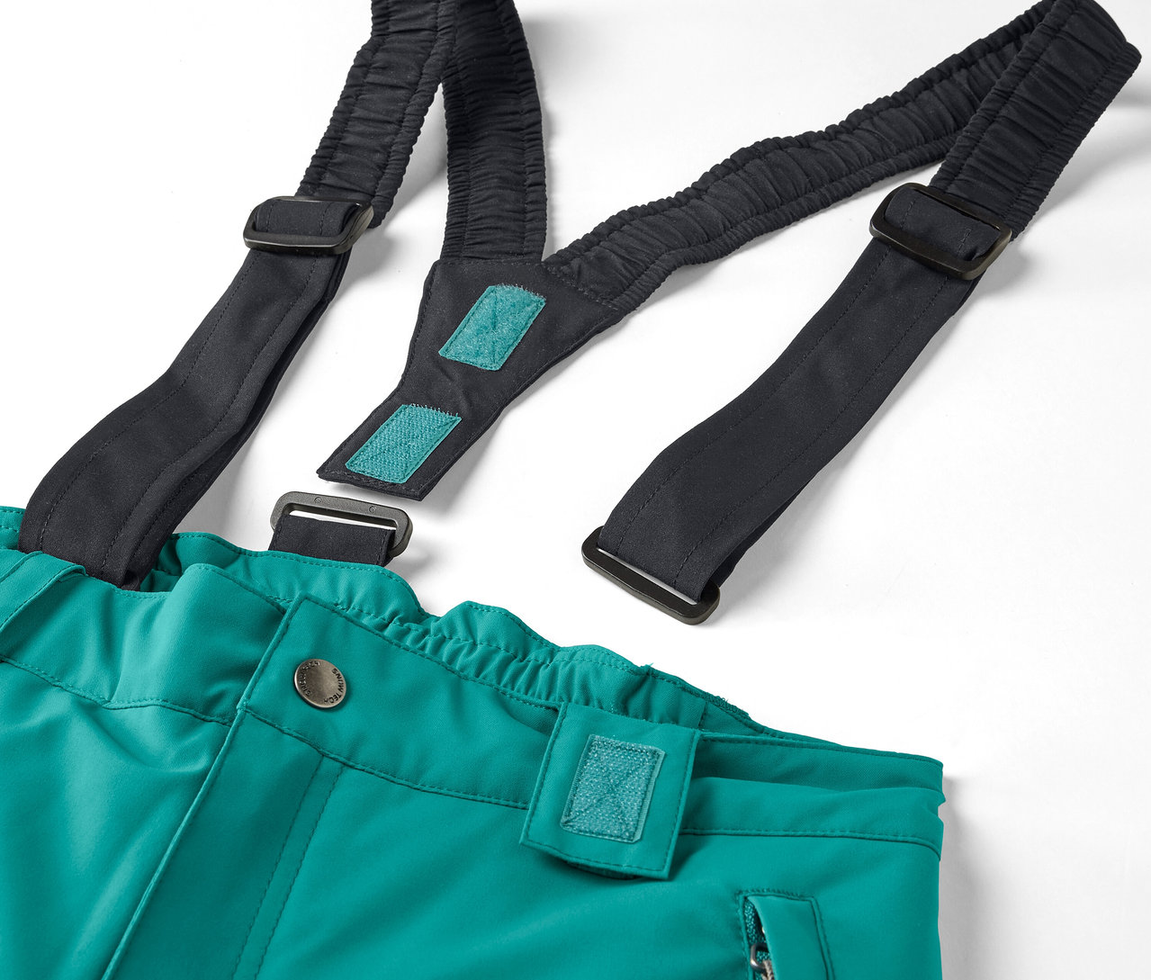 Detail einer grünen Hose mit schwarzen, elastischen Hosenträgern auf weißem Hintergrund.