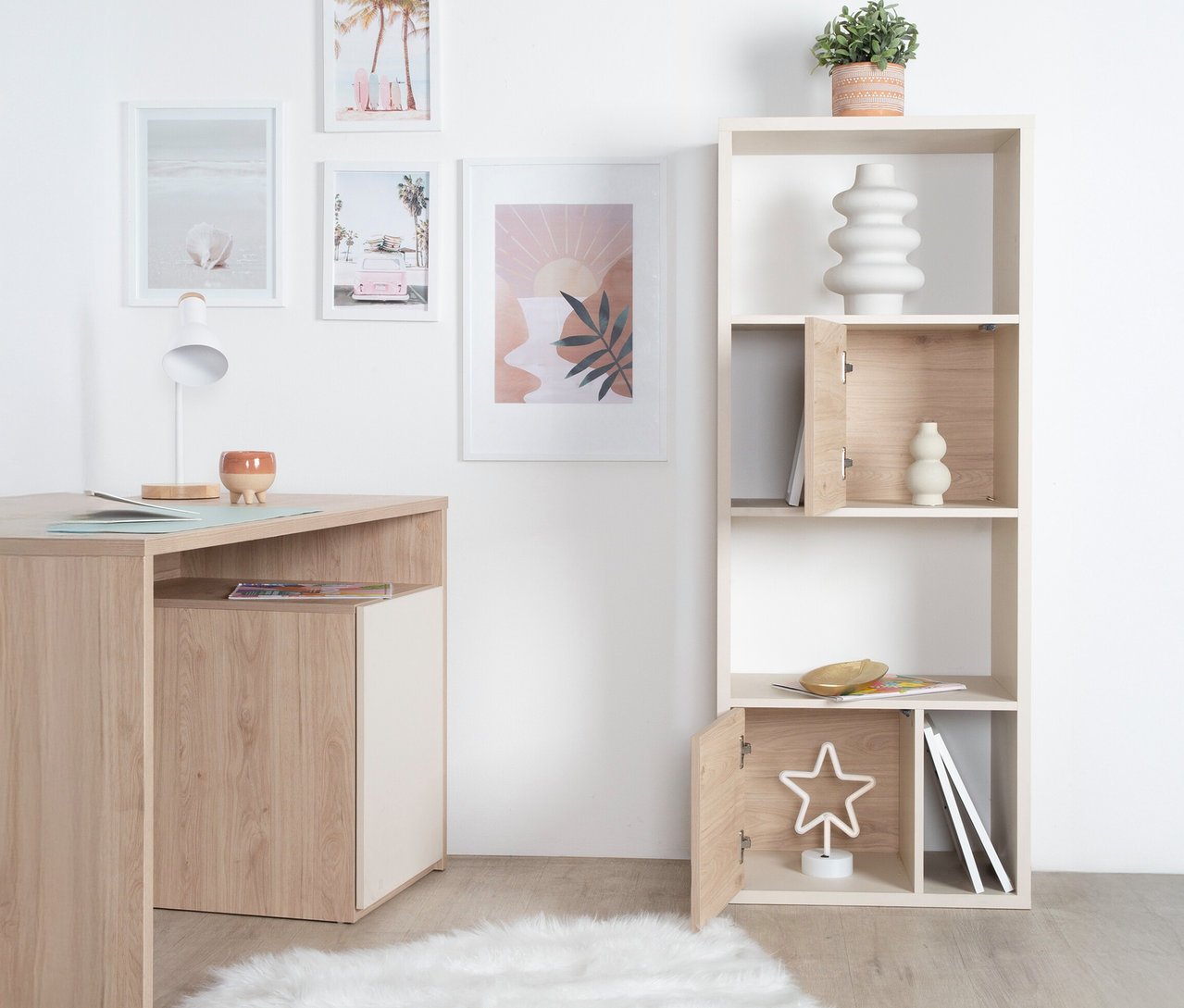 Das Bild zeigt einen Schreibtisch mit einer Lampe und das Roba Regal »Louisa« an einer Wand. Das Regal ist teilweise geöffnet und mit Deko-Objekten gefüllt.