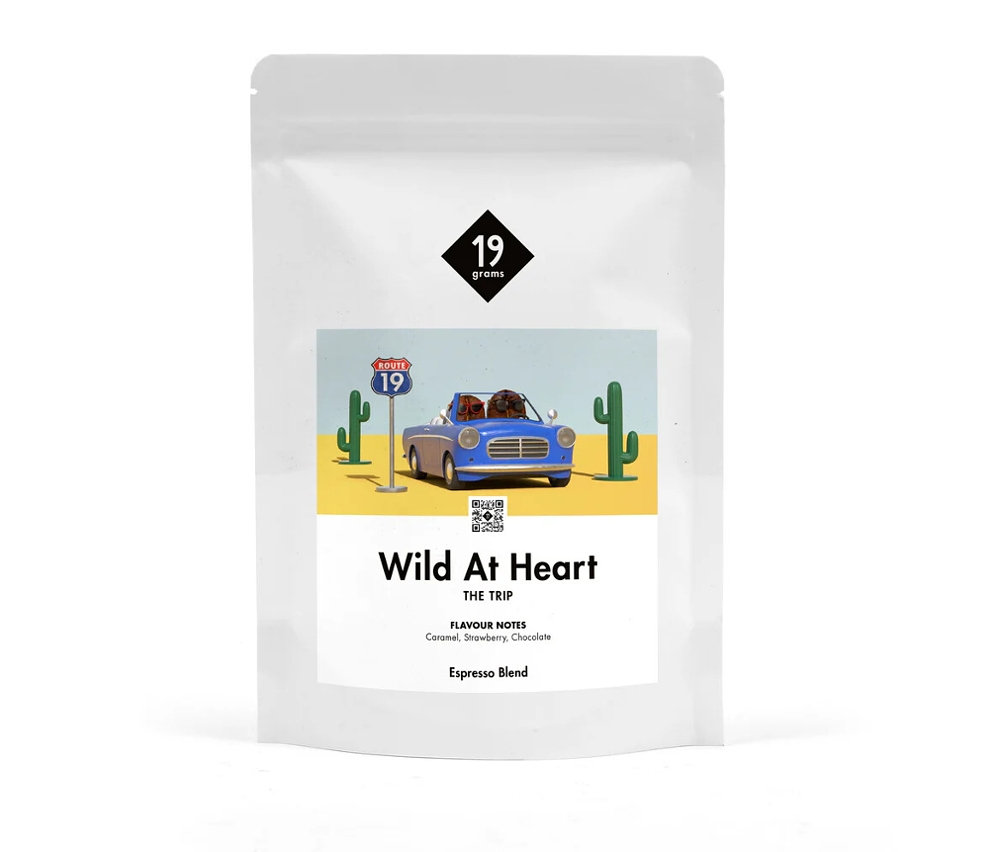 Weiße Verpackung von 19grams Wild at Heart Espresso ganze Bohne mit einer Illustration einer Wüstenlandschaft mit blauem Auto.