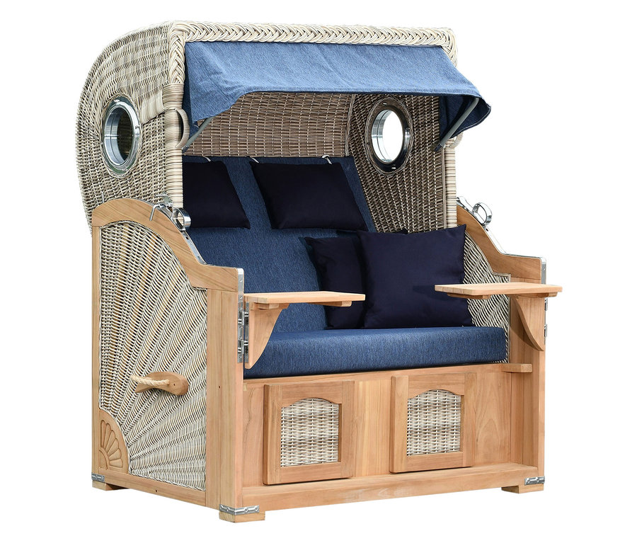 Ein geflochtener Strandkorb mit blauem Stoffdach und blauen Kissen steht im Studio.