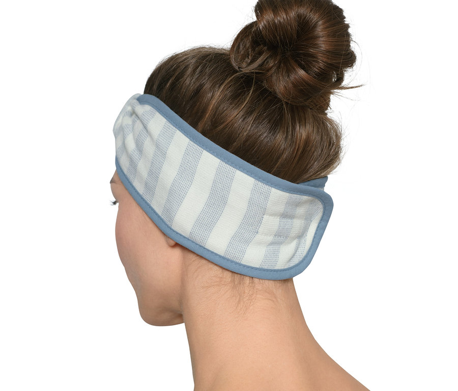 Rückansicht einer Frau mit braunem Haar, die ein gelbes, weiß-blau gestreiftes Kosmetik-Stirnband trägt.