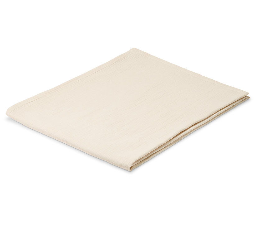 Gefaltete, beige Tischdecke aus Musselin auf weißem Hintergrund.