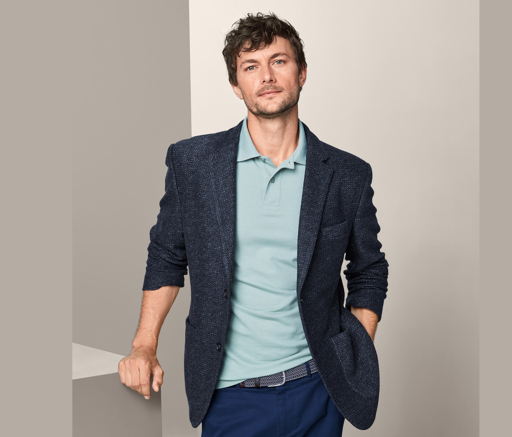 Mann trägt ein Sakko und ein Poloshirt.