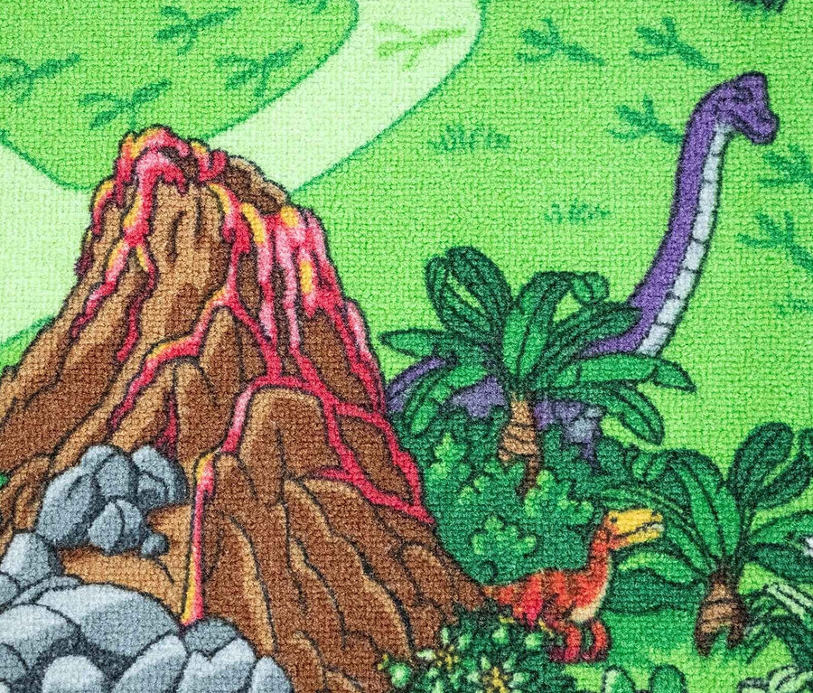 Detailaufnahme eines Kinderteppichs mit Dinosaurier-Motiv, der einen braunen Vulkan, einen violetten Dinosaurier und einen orangefarbenen Raptor auf grünem Hintergrund zeigt.