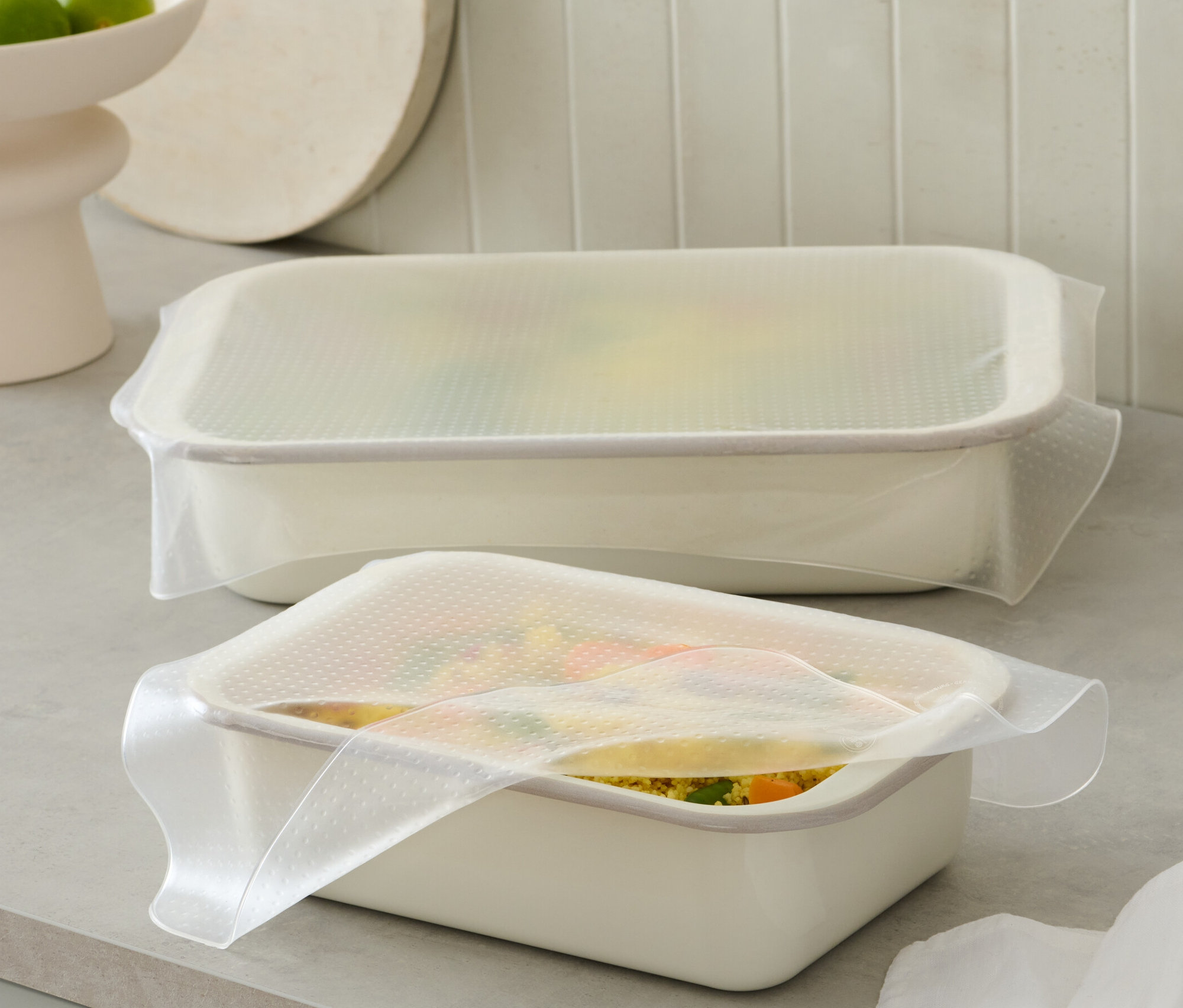 Zwei weiße Behälter sind mit 2 Silikon-Frischhaltefolien abgedeckt.