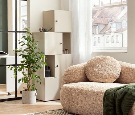 Wohnzimmer mit beigem Sofa, Schieberegal »Lovund«, 2-in-1-Drehtischschrank »Lovund« und Raumteiler »Lovund«.