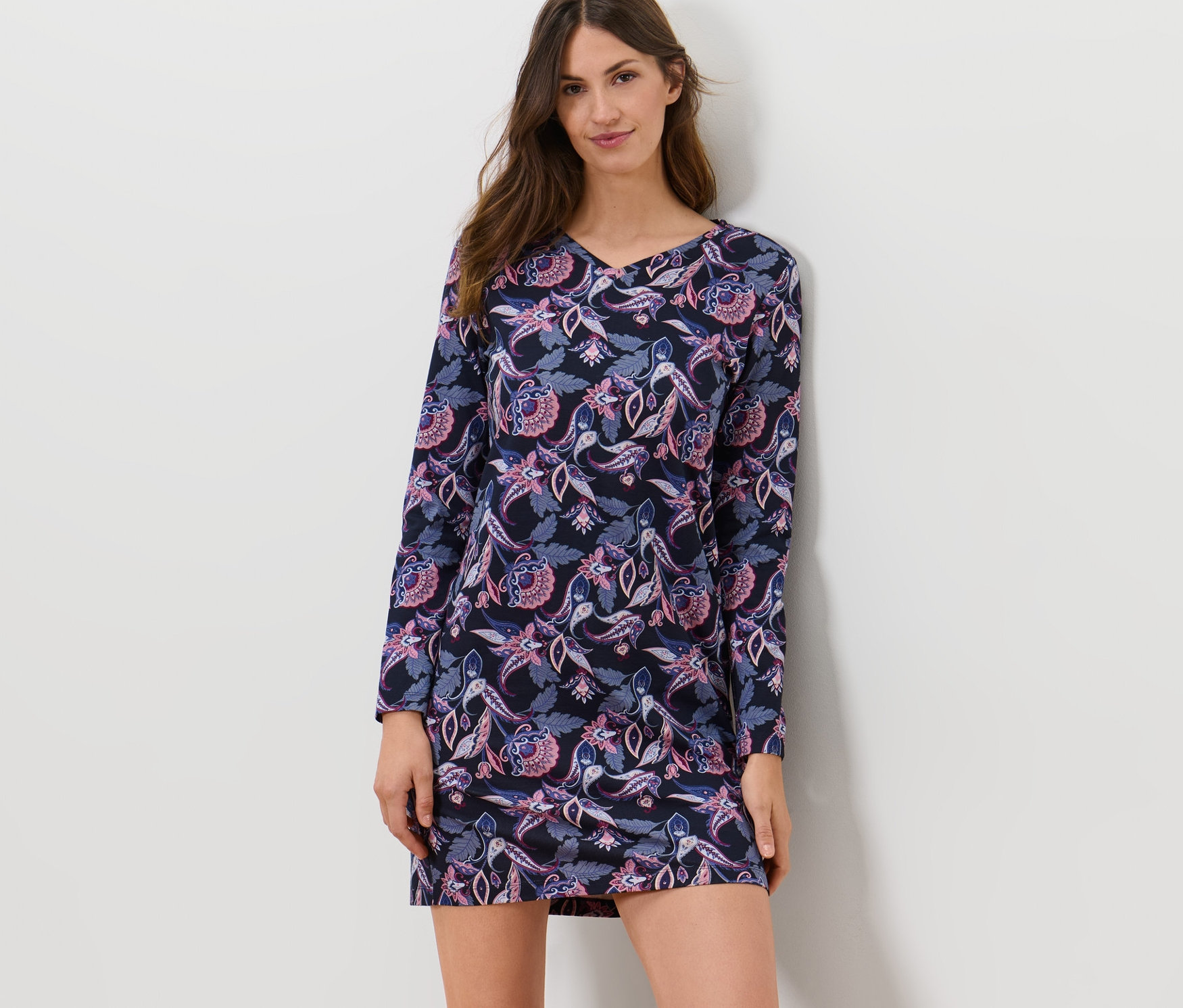 Frau posiert in Nachthemd mit Paisley-Muster.