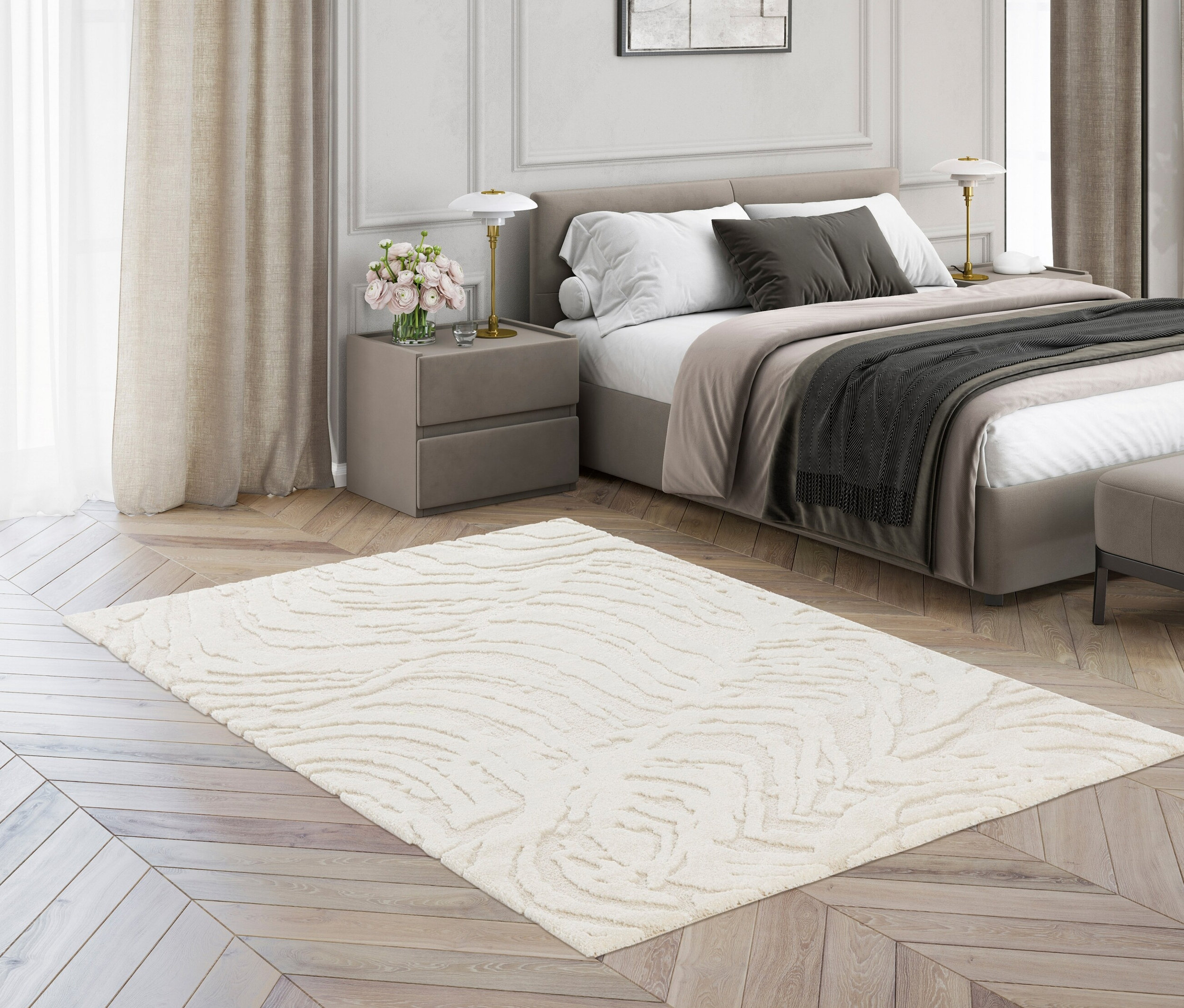 Ein cremefarbener Teppich »Cosmo« Waves liegt auf einem Holzboden in einem Schlafzimmer.