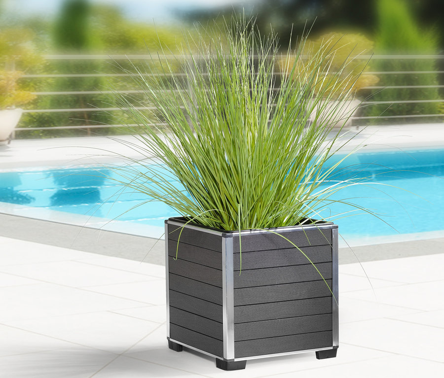 Ein anthrazitfarbener WPC-Pflanzkasten mit Kunststoffeinsatz, ca. 33 x 34 x 33 cm, steht auf weißen Fliesen neben einem Pool.