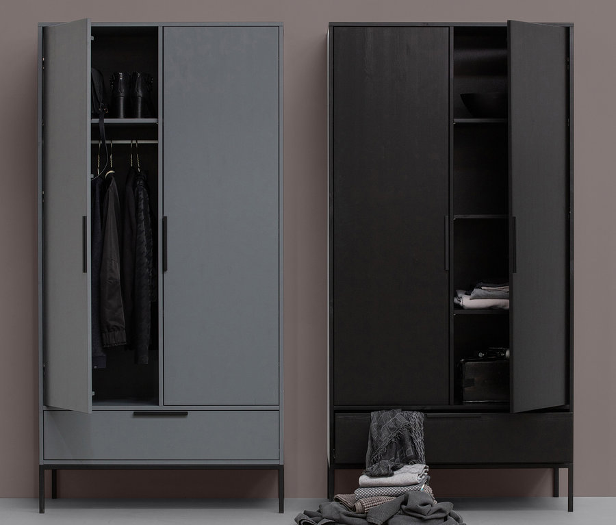Zwei Woood Schränke »Adam«, einer grau mit offener Tür, der andere schwarz mit halb geöffneter Tür und einem Haufen Kleidung davor.