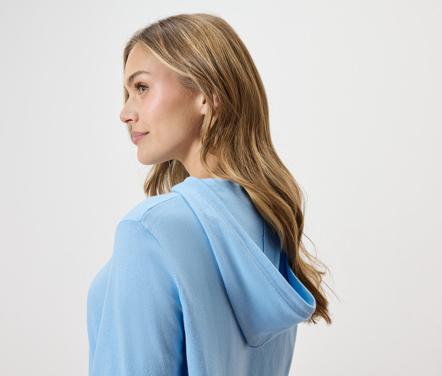 Frau trägt einen hellblauen Hoodie, von der Seite gesehen.
