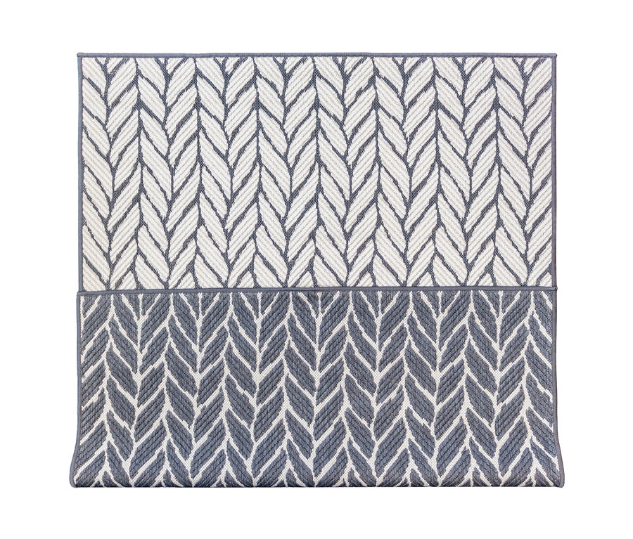 Nahaufnahme eines grau-weißen Outdoor-Wendeteppichs »Knitted Joy« mit Fischgrätenmuster.