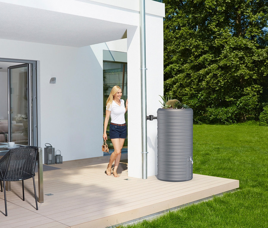 Blonde Frau betritt Terrasse, daneben graues Garantia 2-in-1-Regentonnen-Komplett-Set »Nordic«, ca. 300 l.