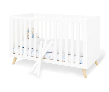 Weißes Pinolino Babybett »Move« mit weißen Seitenteilen und Holzbeinen.