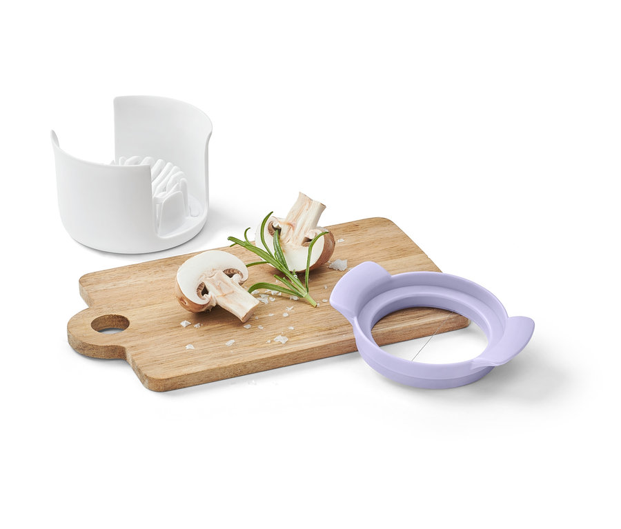 3-in-1-Eierschneider, Pilze und Rosmarin auf einem Holzbrett.