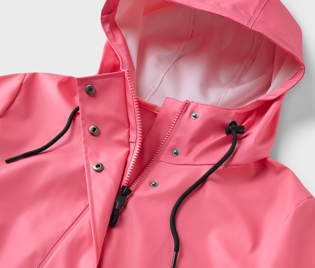 Detailansicht eines rosa Regenmantels mit Kapuze und Reißverschluss.