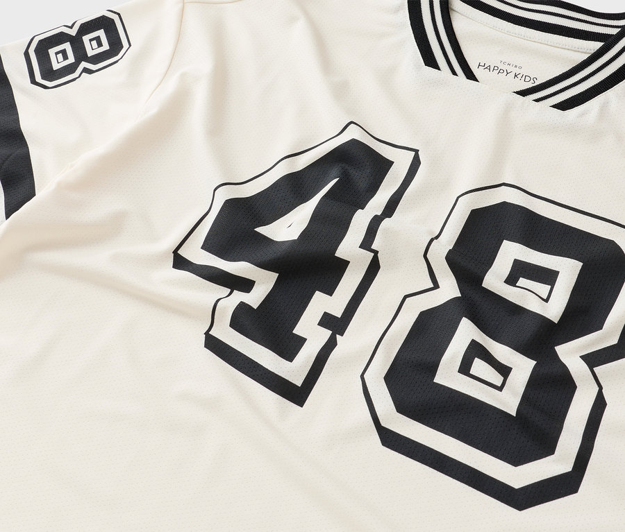 Nahaufnahme eines T-Shirts mit der Nummer 48 in Schwarz auf cremefarbenem Stoff.