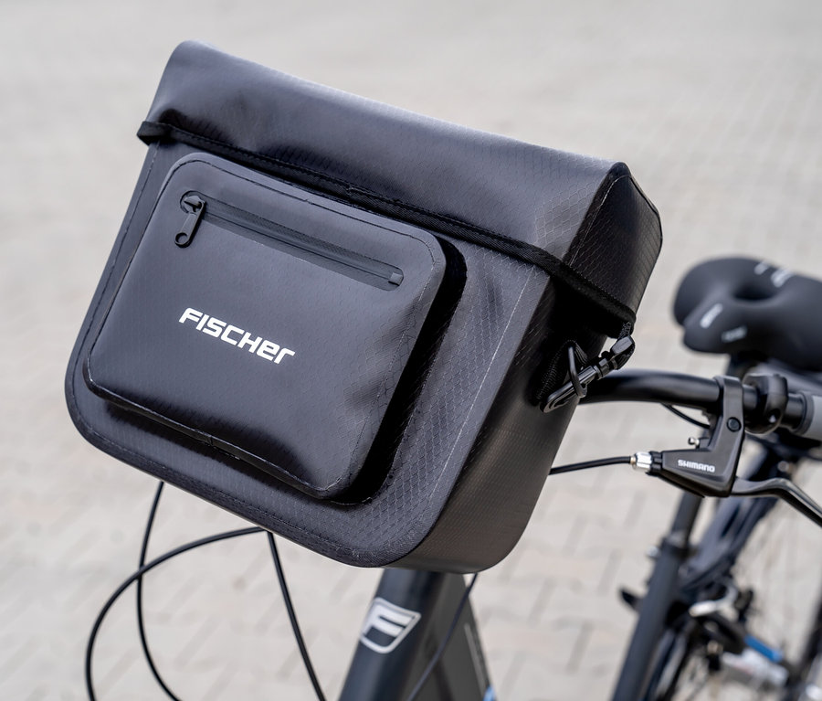 Nahaufnahme einer schwarzen FISCHER Lenkertasche PLUS+ Terra, die an einem Fahrradlenker befestigt ist.