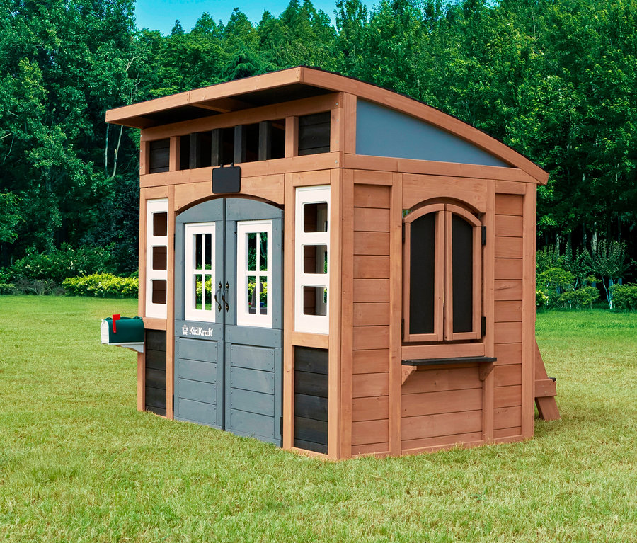 Das Spielhaus Trolli steht auf einer Wiese und hat eine grüne Mailbox, eine graue Tür und weiße Fensterrahmen.