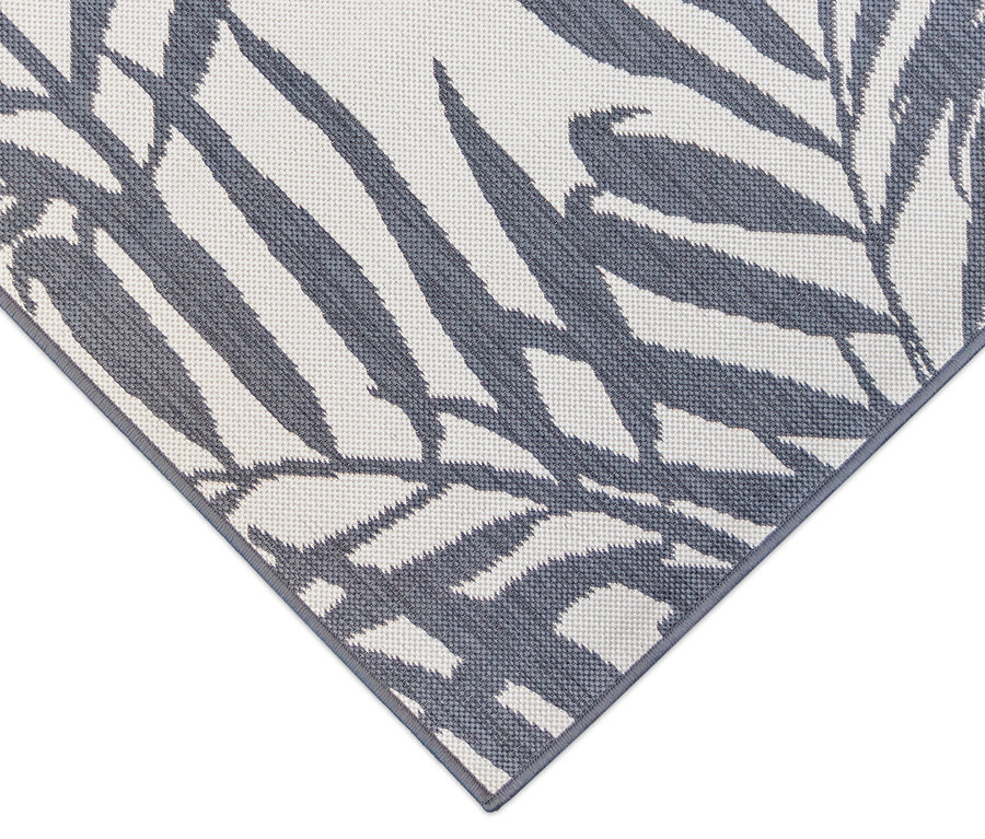 Detailansicht eines grau-weißen Outdoor-Wendeppichs »Palm Tree« mit Palmenblattmuster.