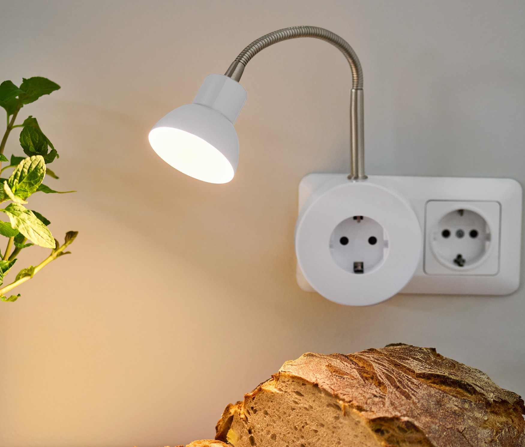 Beleuchtete LED-Schwenkleuchte über Brot und Teller mit Aufstrich.