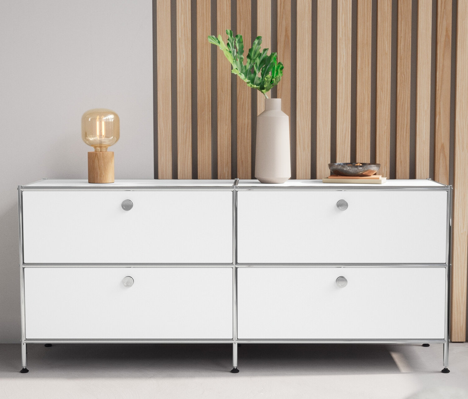 Weißes Lowboard Metall »CN3« mit 4 Schubladen und eine Tischleuchte aus Holz stehen nebeneinander.