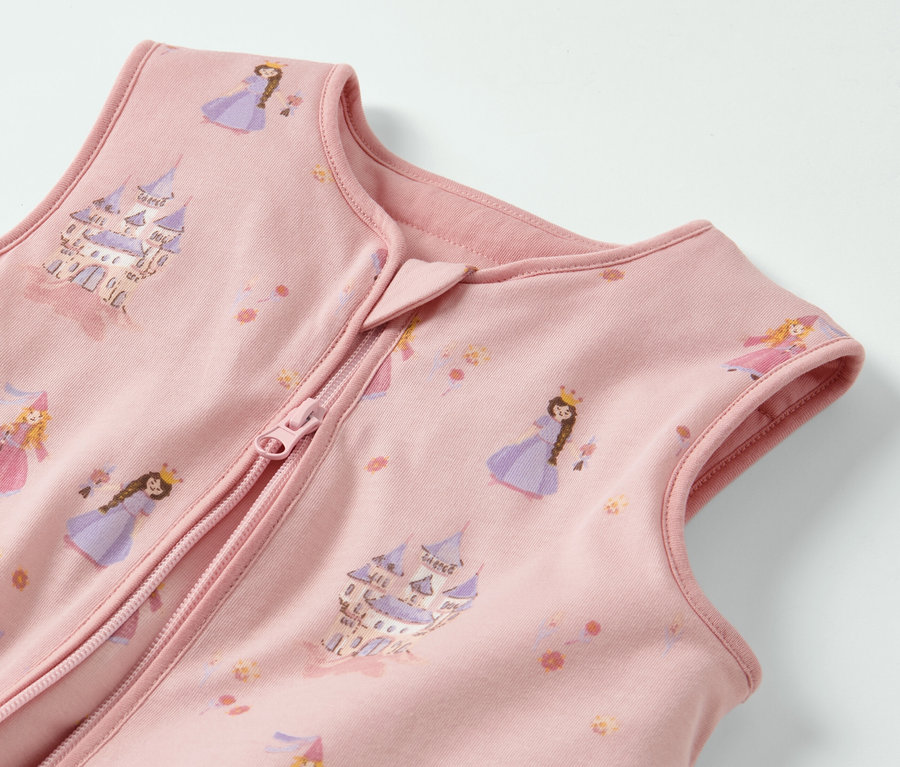 Detailansicht eines rosa Schlafsacks mit Beinen, bedruckt mit Prinzessinnen und Burgen.