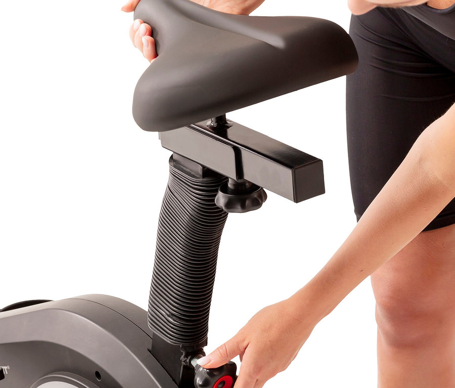 Frau justiert den Sitz am Christopeit Hybrid Crosstrainer 2-in-1 »AX 6500«.