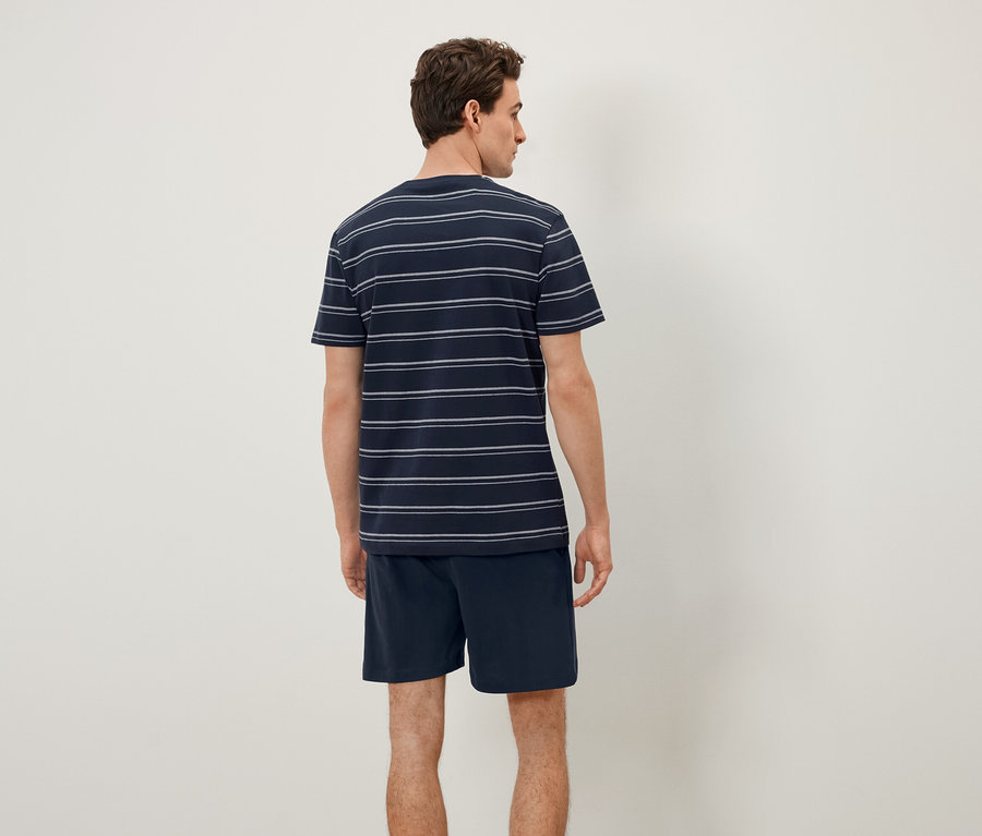 Mann von hinten trägt ein gestreiftes T-Shirt und Shorts.