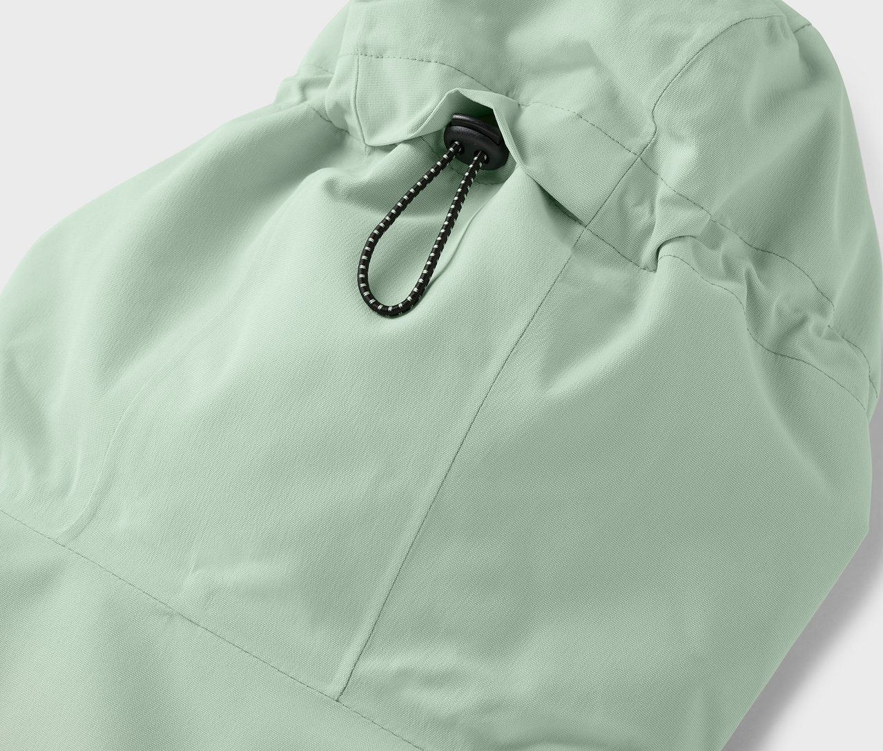 Detailansicht der Kapuze einer hellgrünen Jacke mit Kordelzug.
