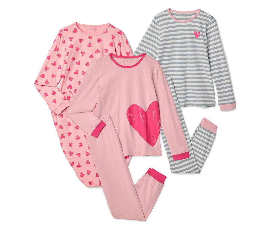 Drei Kinderpyjamas sind auf einem weißen Hintergrund abgebildet. Ein Pyjama ist rosa mit roten Herzen, einer ist rosa mit einem großen roten Herzen und einer ist grau-weiß gestreift mit einem kleinen roten Herz.